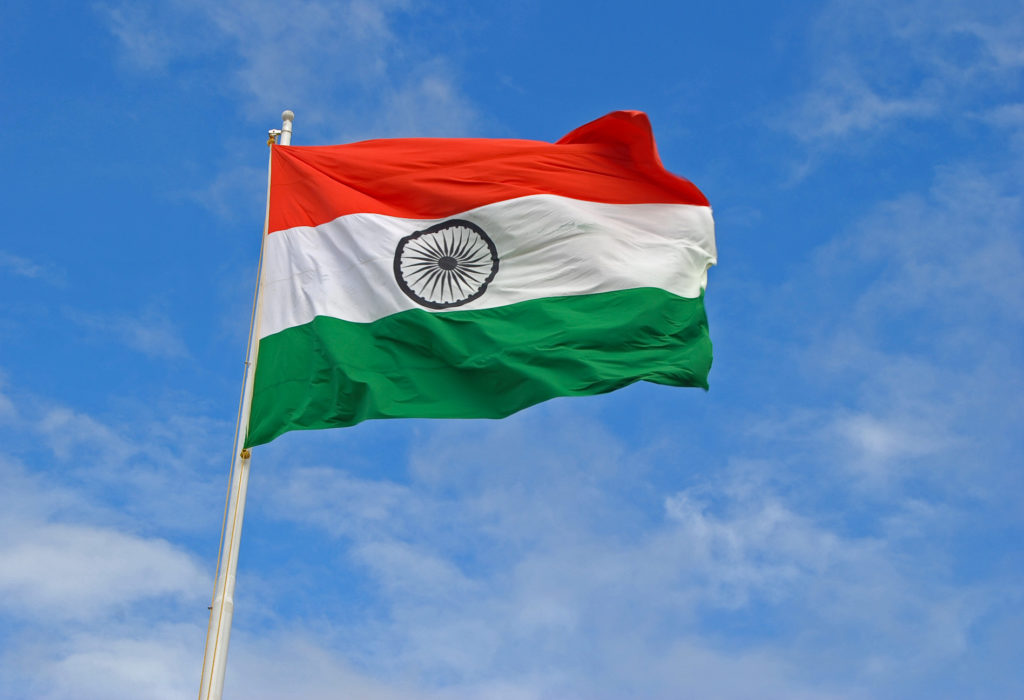 The Indian Flag flying high on top of a flag pole